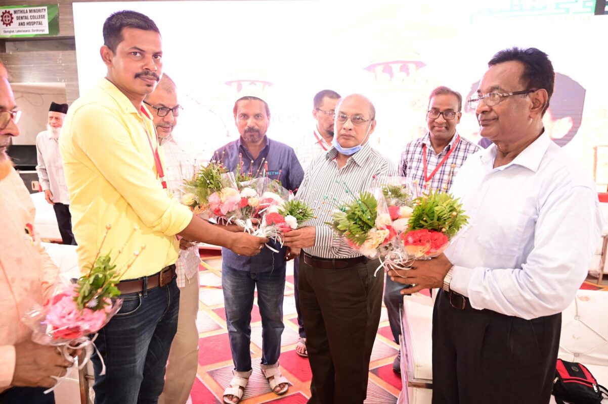 Organisers welcoming guests with bouquets at a Trust event in Darbhanga