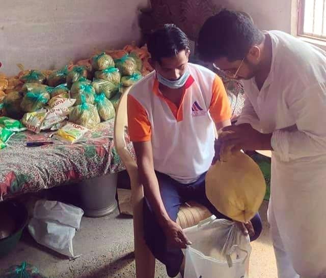 Volunteers weighing and packing relief rations into family bags
